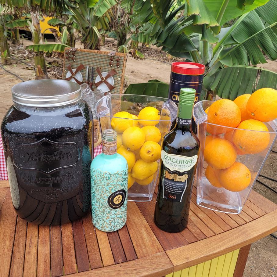 Una barra de bar con productos de vermut y algunas frutas