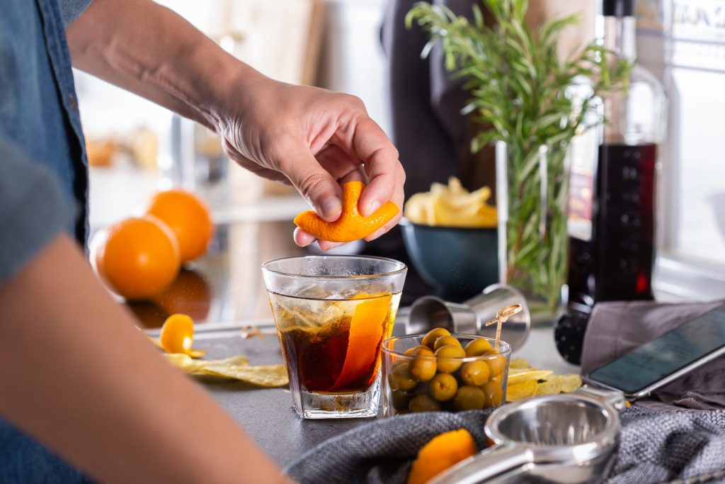 Mixologist making refreshing cocktail with vermouth at home